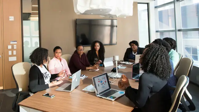 A group of women participating in a cybersecurity workshop, with laptops on the table